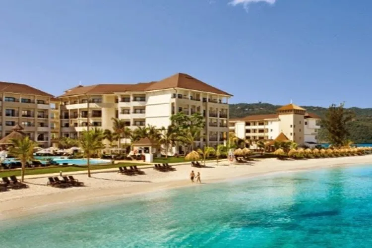 Beach at Secrets Wild Orchid: Serene white-sand beach at Secrets Wild Orchid Montego Bay with clear turquoise water and gentle waves.